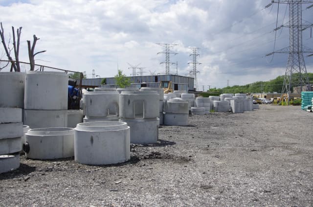 Precast concrete manhole sections stacked in a yard